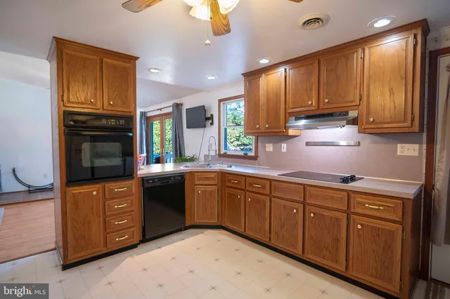 a kitchen with stainless steel appliances granite countertop wooden cabinets a sink and dishwasher