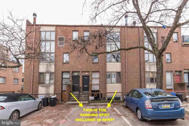 a car parked in front of a brick house