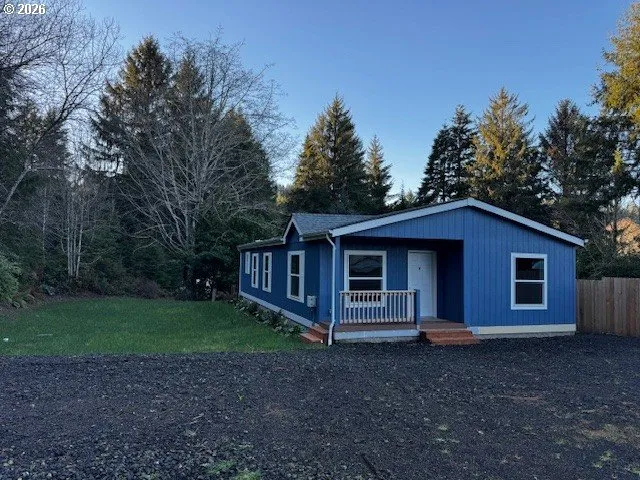 a view of a house with a yard and large trees