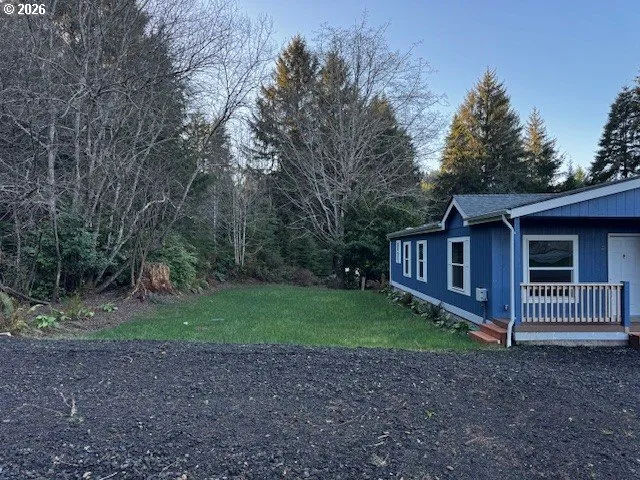 a view of a house with a yard and large trees