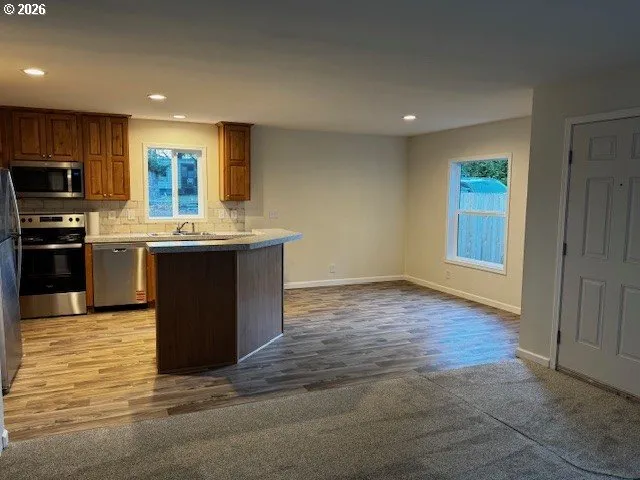 a kitchen with stainless steel appliances granite countertop a stove a sink and a refrigerator