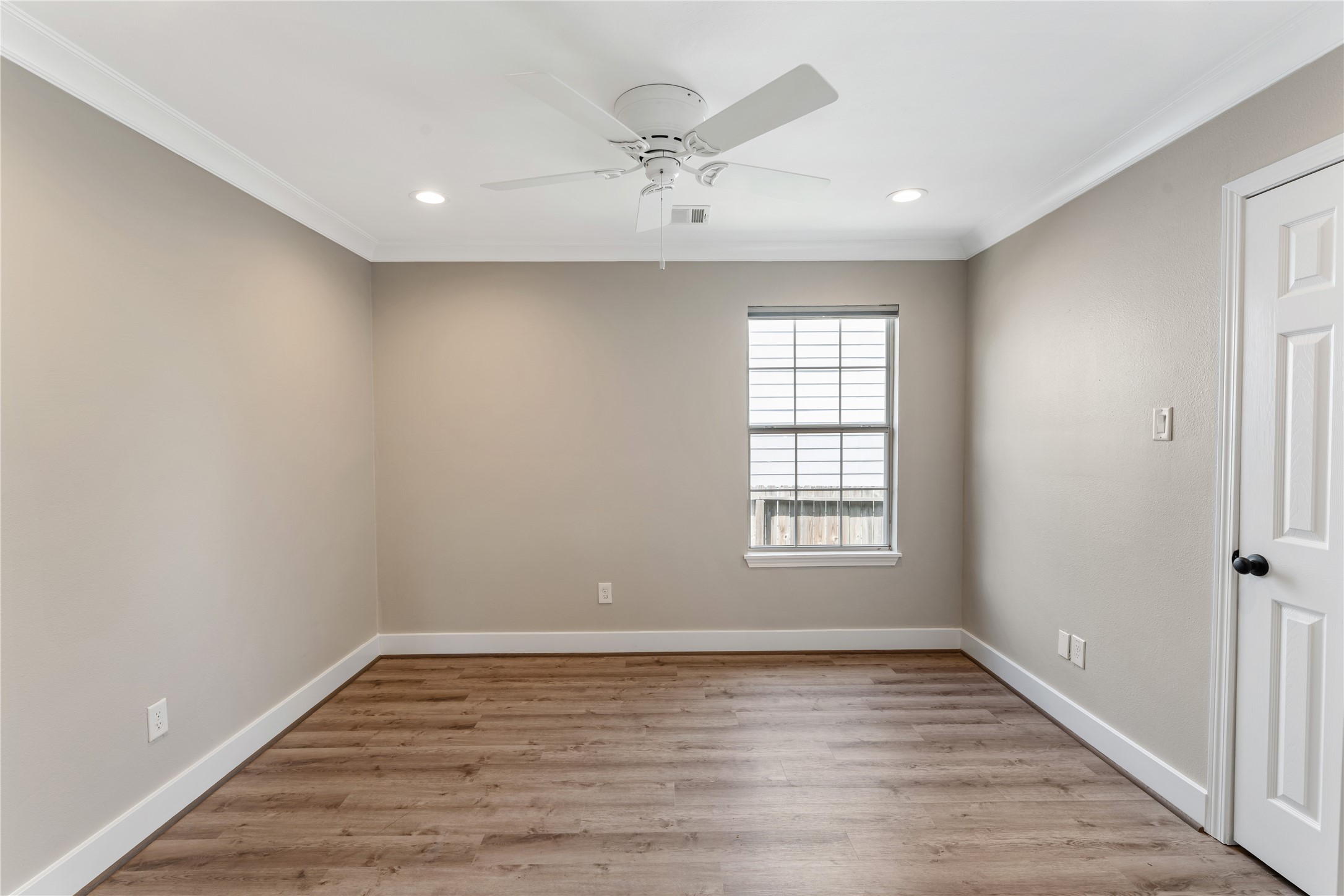 809 East 40th Street Houston, TX 77022 - Photo 20 of 27 Light-filled secondary bedroom with updated flooring, neutral tones, and a ceiling fan for comfort. Clean finishes and a functional layout make this space ideal for guests, family, or a home office. Consistent updates throughout the home reflect thoughtful renovation and care.