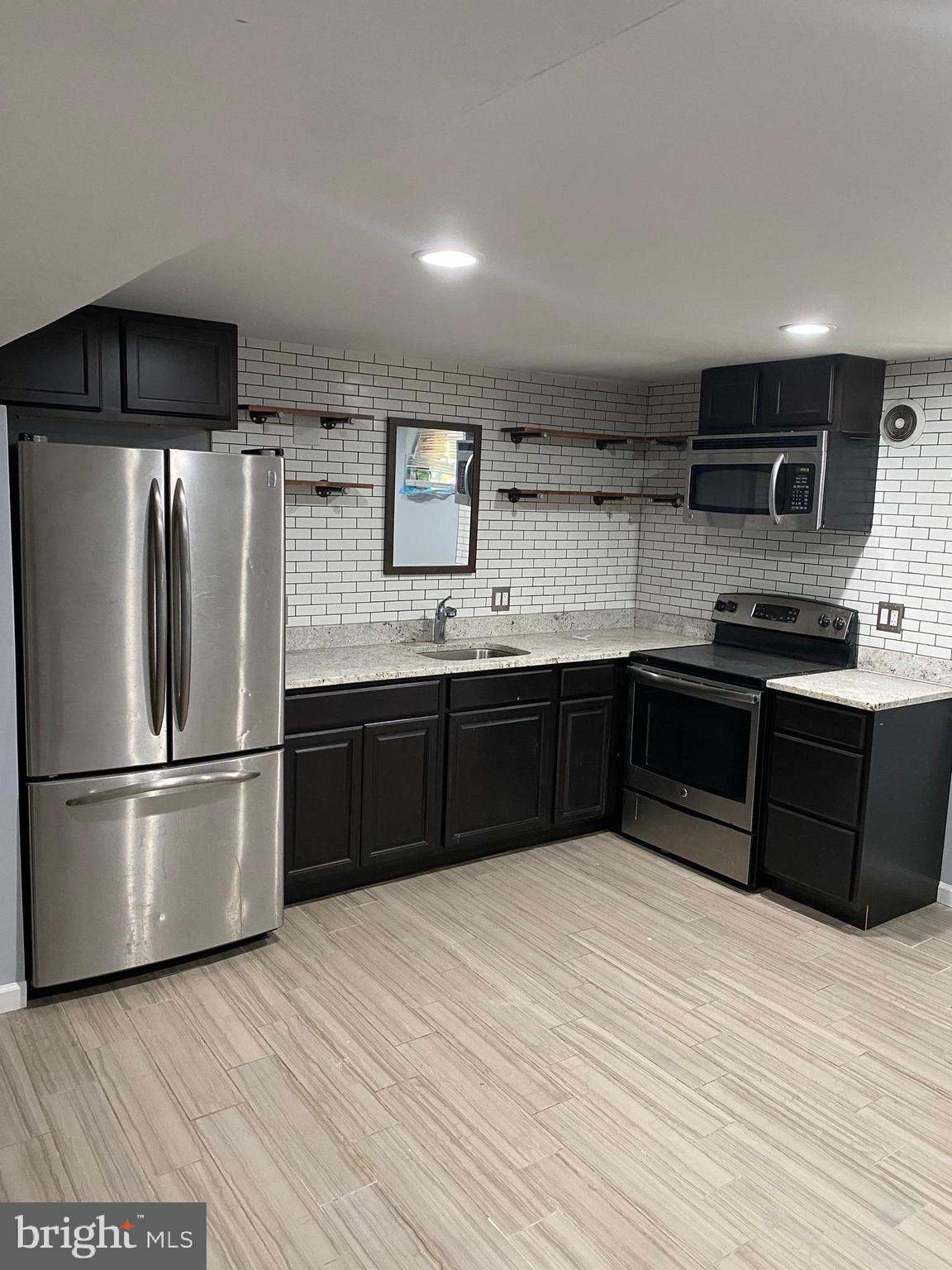 5806 Burgess Road District Heights, MD 20747 - Photo 1 of 11 a kitchen with stainless steel appliances granite countertop a refrigerator and a sink