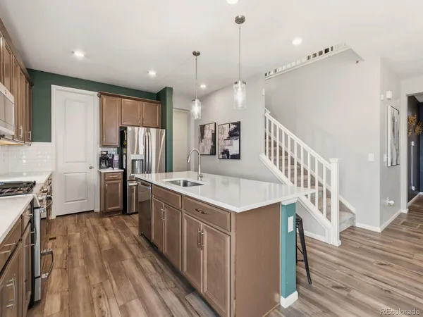 a kitchen with kitchen island granite countertop lots of counter top space a sink appliances and cabinets