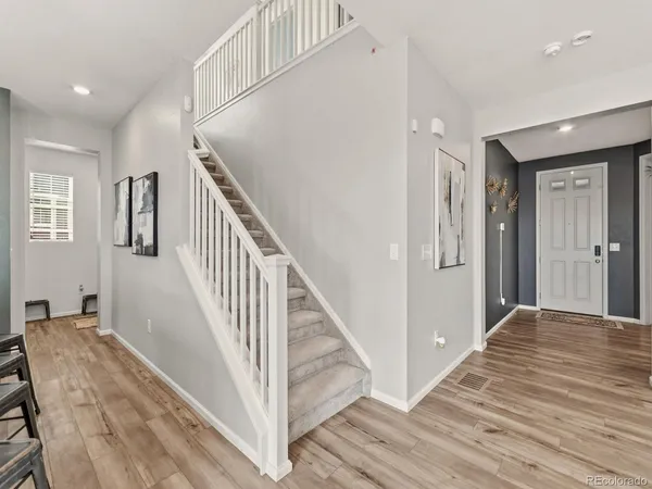 a view of a hallway with wooden floor and staircase