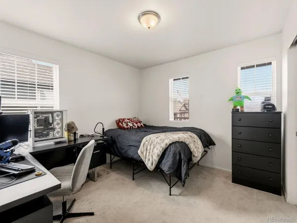 a bedroom with a bed and a computer on the desk