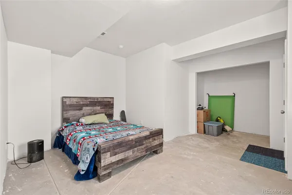 a bedroom with a bed and a lamp on dresser