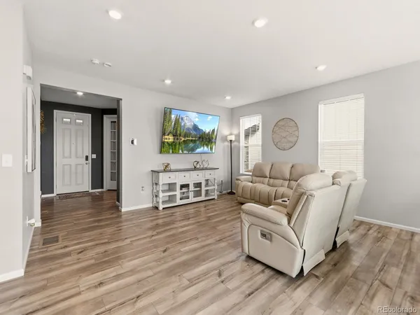 a living room with furniture and a wooden floor