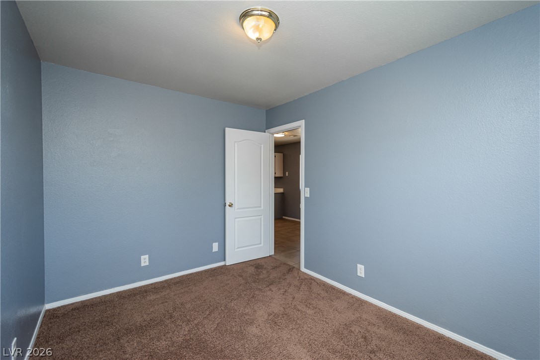 1444 Star Road Pahrump, NV 89048 - Photo 19 of 37 Smooth plaster walls and soft carpeting define this versatile secondary bedroom space.