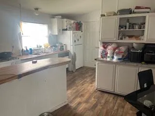 an empty room with wooden floor a fireplace and windows