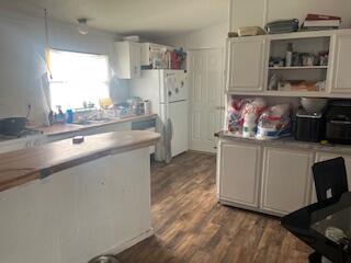 6806 North County Road 1630 Shallowater, TX 79363 - Photo 2 of 40 a kitchen with cabinets and wooden floor