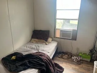 a bed sitting in a bedroom next to a window