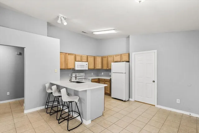 a kitchen with a sink a refrigerator and cabinets