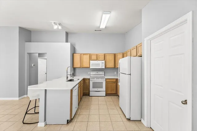 a kitchen with a sink a refrigerator and cabinets