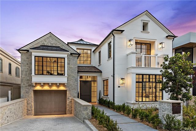 a front view of a house with glass windows and yard