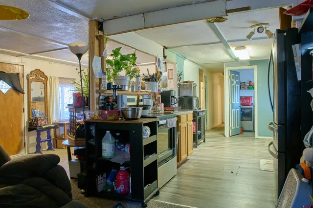 a view of a kitchen with furniture and wooden floor