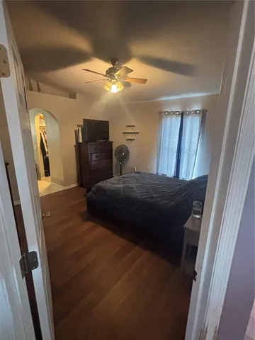 a bedroom with a large bed and a flat tv screen