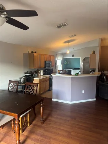 a kitchen with a sink cabinets and wooden floor
