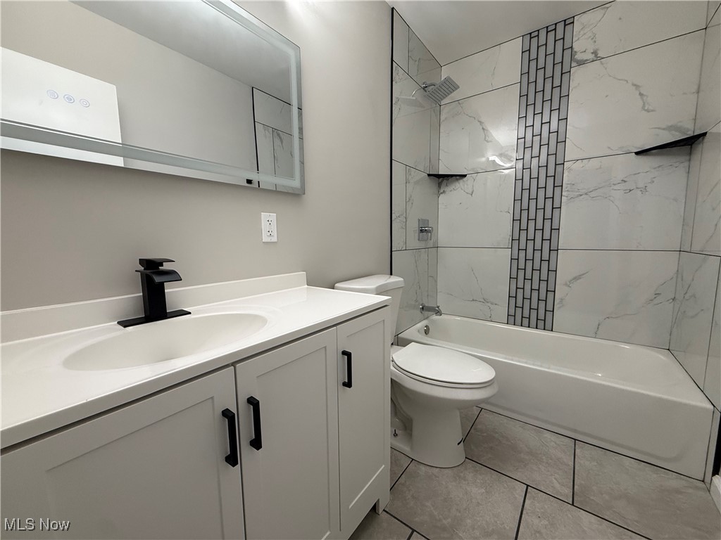 4658 Burleigh Road Cleveland, OH 44125 - Photo 10 of 24 Bathroom featuring vanity, washtub / shower combination, and light tile patterned flooring