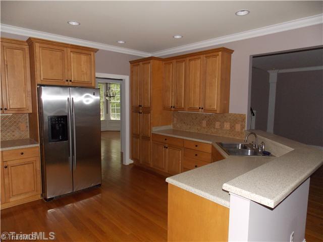 8501 Rosedale Drive Oak Ridge, NC 27310 - Photo 6 of 16 Kitchen. Large kitchen with lots of cabinets, tile back splash. and hardwood floors.. all freshly painted