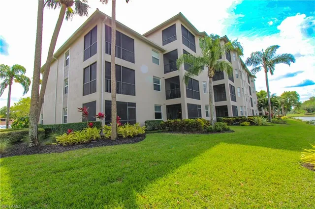 a view of a lake with a big yard and large trees