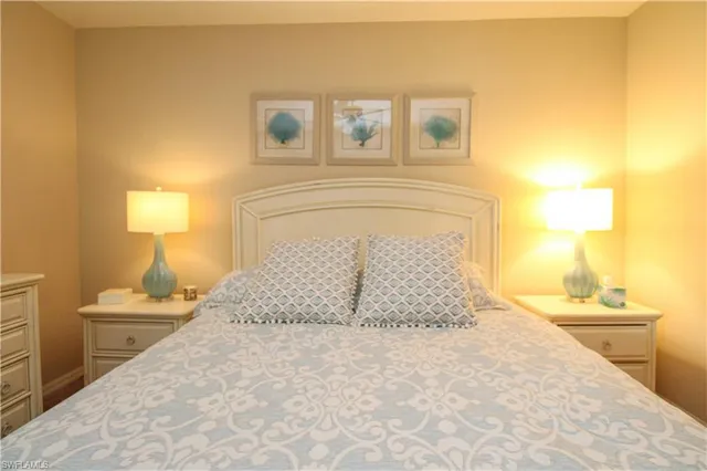 a bedroom with a bed and a flat tv screen on dresser