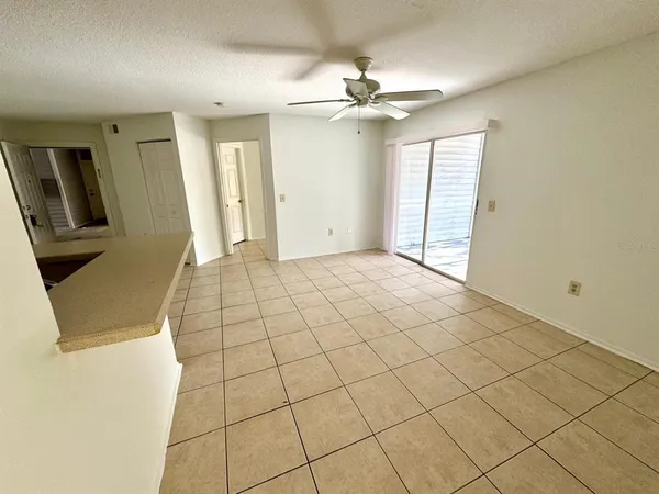a view of an empty room and chandelier fan