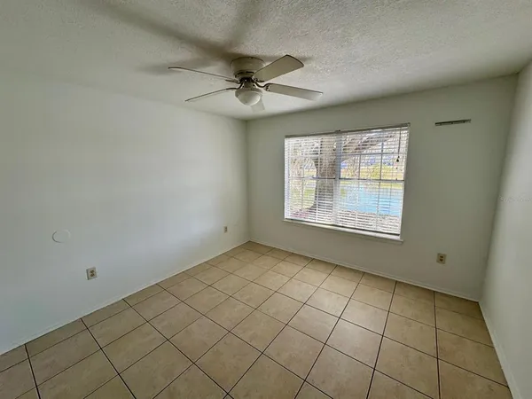 an empty room with a white cabinet and a window