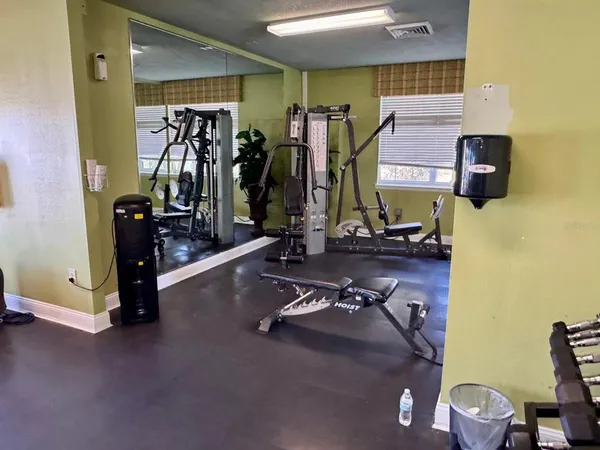 a living room with furniture gym equipment and a large window