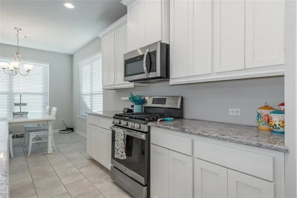 a kitchen with stainless steel appliances granite countertop a stove a sink and a white cabinets