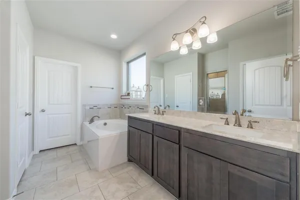 a spacious bathroom with a double vanity sink mirror and a bathtub