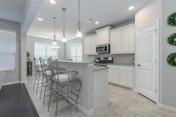 a kitchen with stainless steel appliances kitchen island granite countertop a refrigerator and microwave