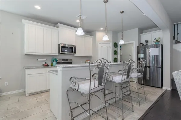 a kitchen with stainless steel appliances granite countertop a stove a sink a refrigerator and a refrigerator