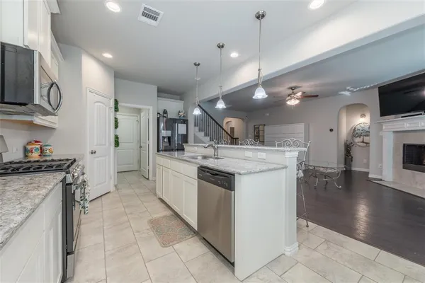 a kitchen with stainless steel appliances granite countertop a sink and a stove