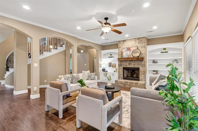 a living room with furniture a fireplace and a ceiling fan