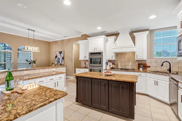 a kitchen with stainless steel appliances granite countertop a stove a sink and a white refrigerator