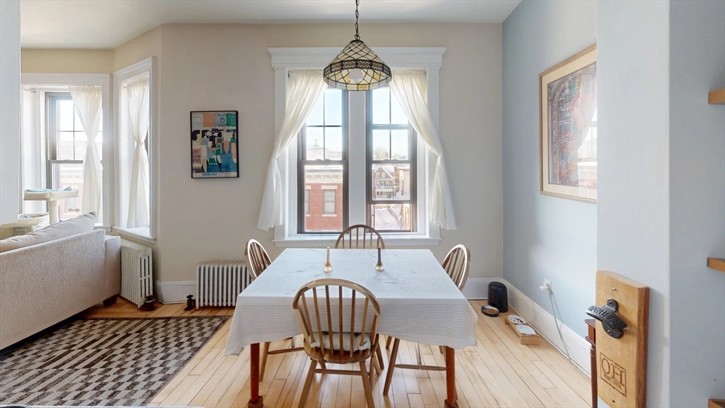 a dining room with furniture a chandelier and wooden floor