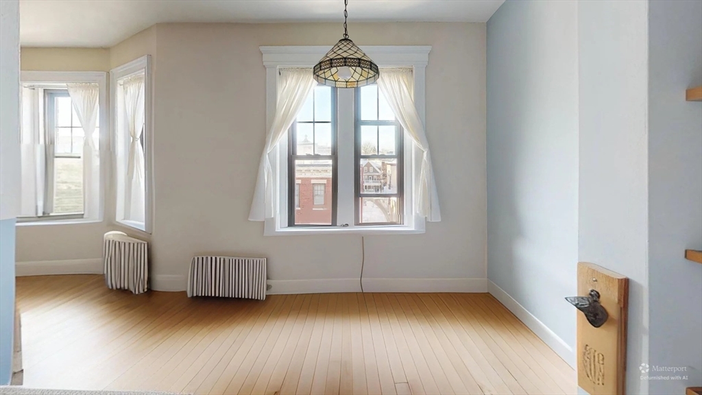 1161 Commonwealth Avenue, Unit 8 Boston, MA 02134 - Photo 10 of 17 a view of an empty room with window and wooden floor