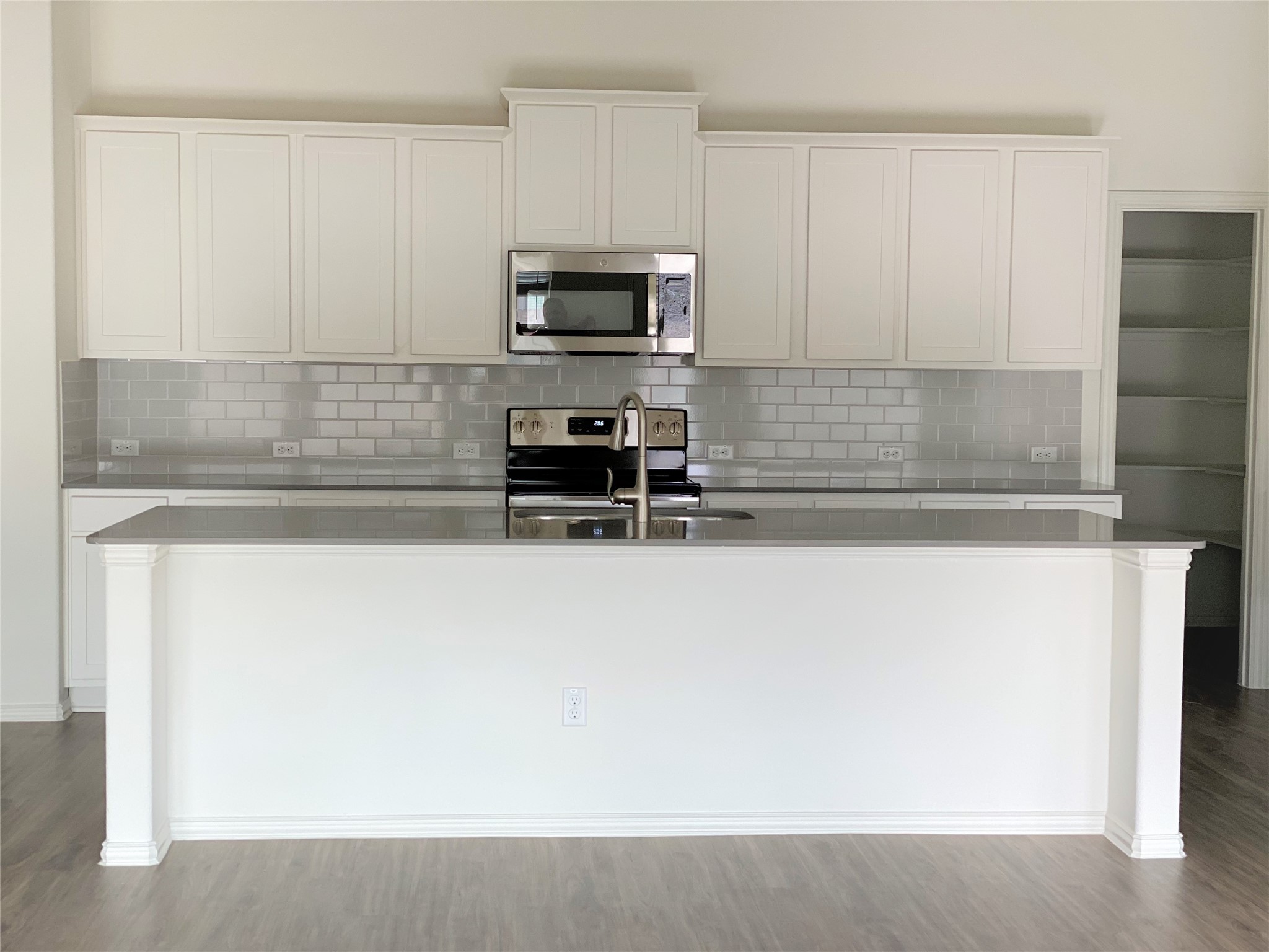 1309 Terrace View Georgetown, TX 78628 - Photo 8 of 36 A contemporary kitchen features sleek countertops, pristine cabinetry, and a subway tile backsplash.