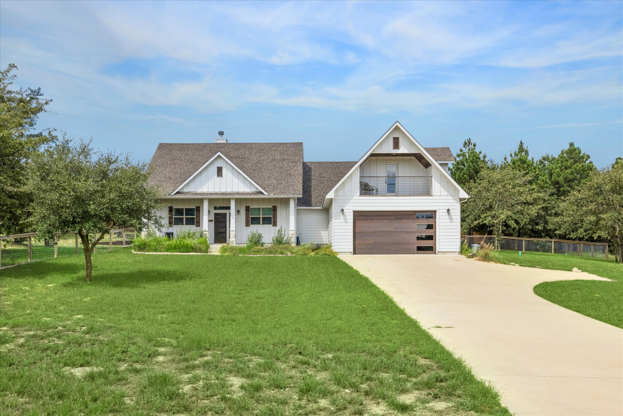 116 Mallard Road Bastrop, TX 78602 - Photo 31 of 31 Manicured lawns and a paved driveway lead to this modern craftsman home with a garage.