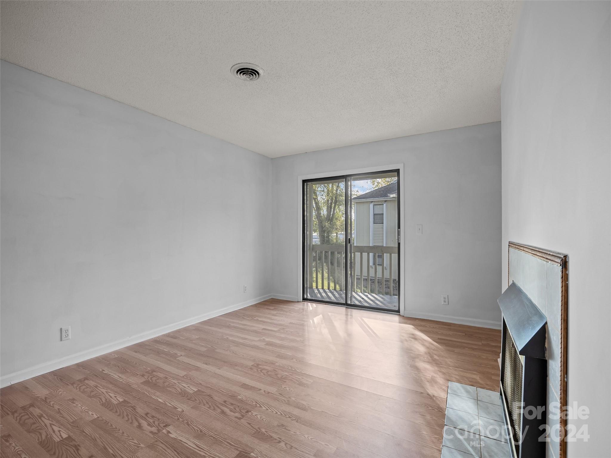 110 Heywood Road, Unit 14D Arden, NC 28704 - Photo 12 of 20 a view of an empty room with a fireplace and a window
