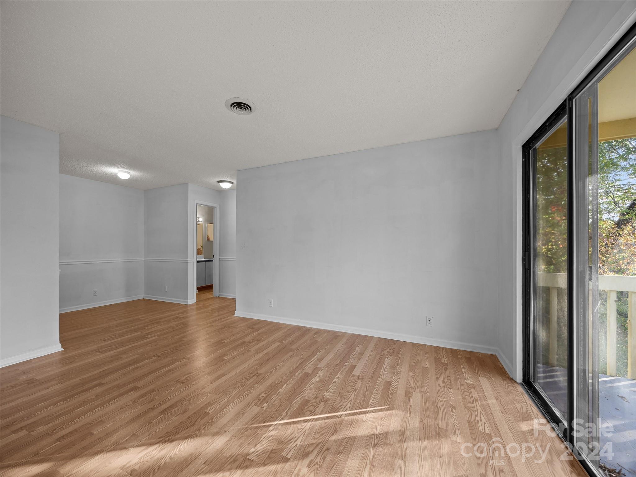 110 Heywood Road, Unit 14D Arden, NC 28704 - Photo 3 of 20 a view of an empty room with wooden floor and a window
