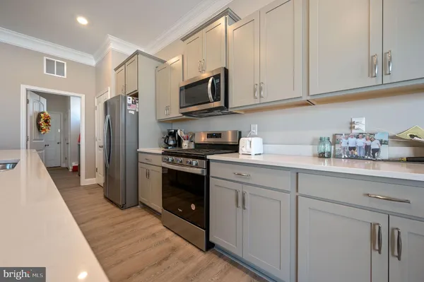a kitchen with stainless steel appliances granite countertop a refrigerator and a stove top oven