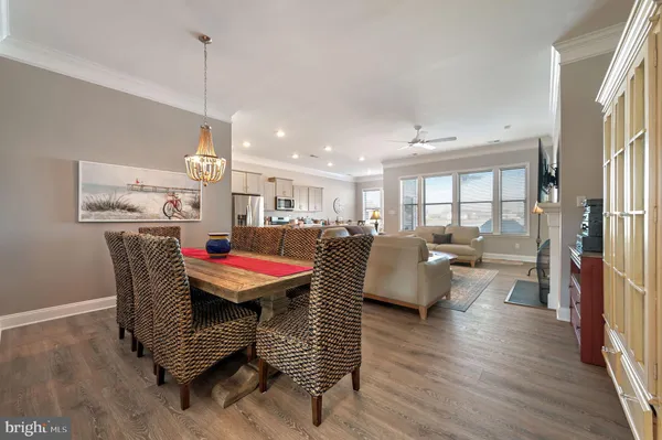 a dining room with furniture a chandelier and wooden floor