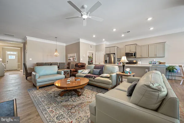 a living room with furniture and a view of kitchen