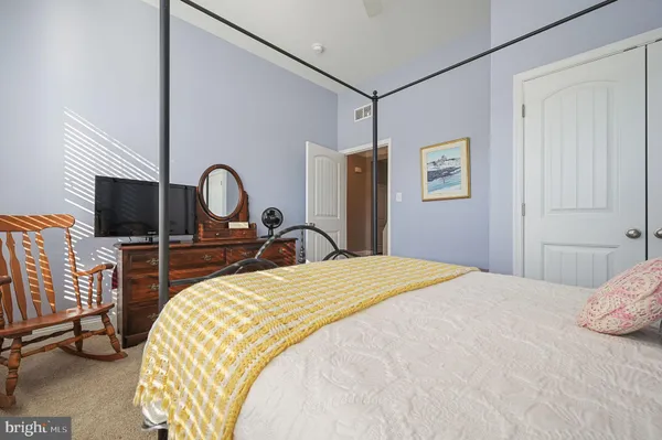a bedroom with a bed and dresser with mirror