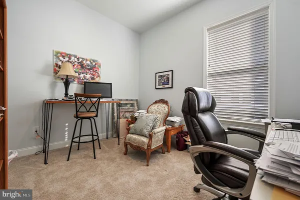 a view of a workspace with furniture and a window
