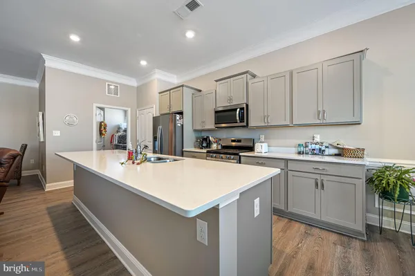 a large kitchen with kitchen island a sink appliances and cabinets