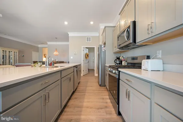 a large kitchen with stainless steel appliances lots of counter space and a sink