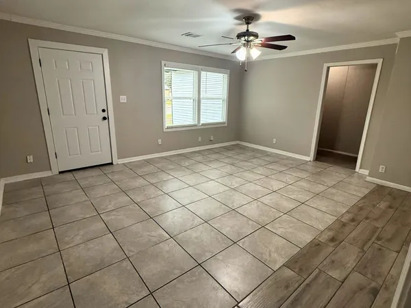 an empty room with windows and fan